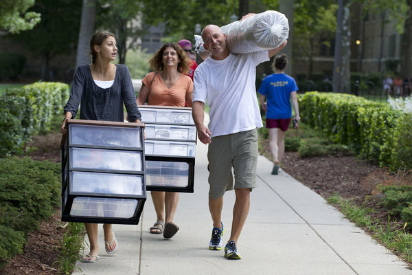 Parents help their daughter move into her residence hall