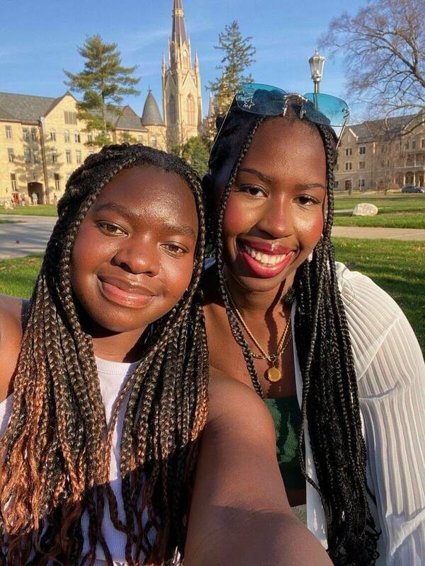 Two Notre Dame students pose in front of the Basilica.
