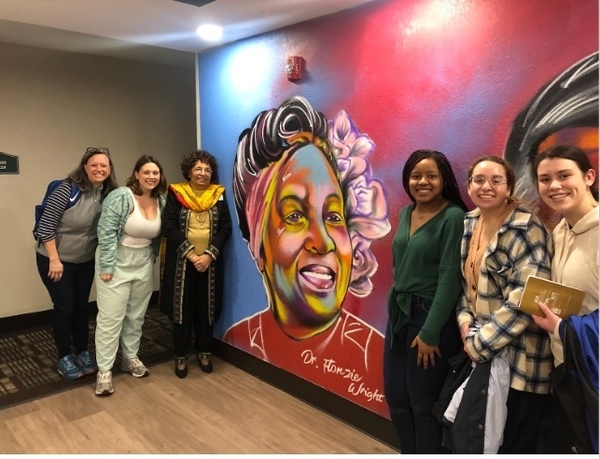 Students in CSC pose with Dr. Flonzie Wright, the first Black woman elected to a public office in Mississippi, in front of her mural.
