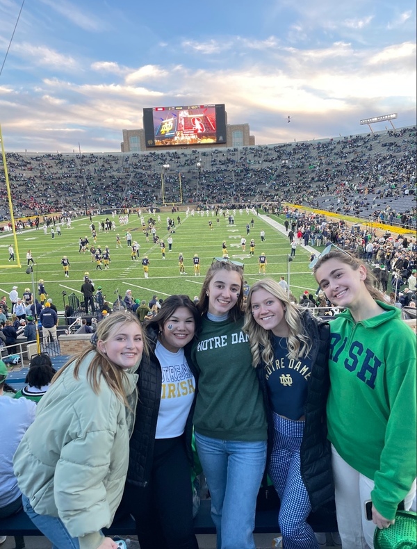 Ellie Villaruz with friends at a Notre Dame home football game, posing in stadium.